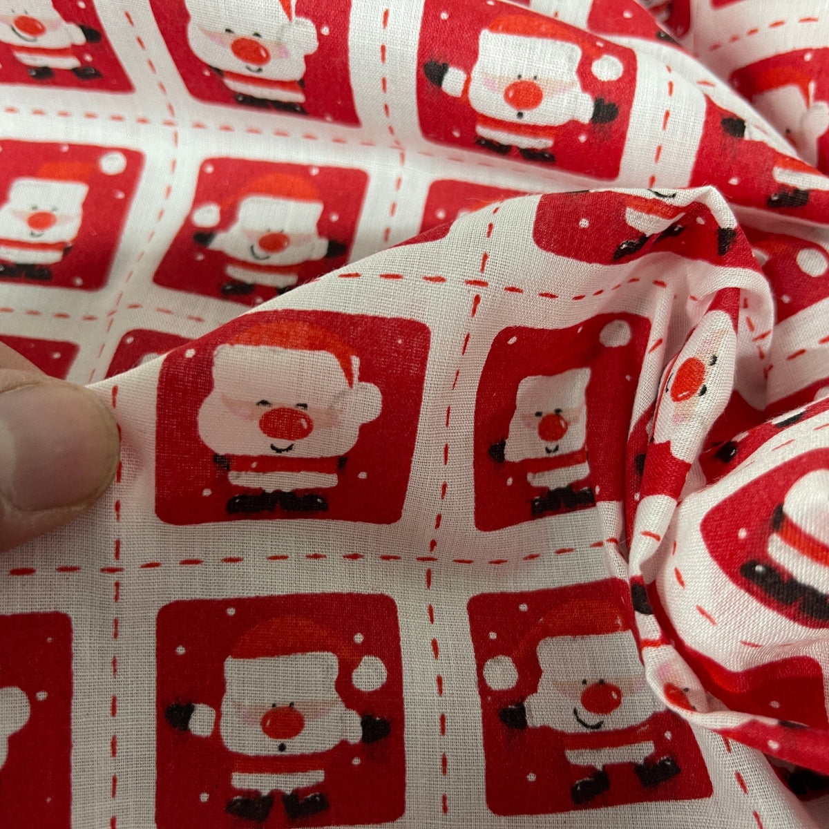 Santa Stamps Christmas polycotton fabric in white, red and green, ideal for gift bags and festive crafts