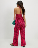 Woman wearing a red leopard print jumpsuit on a white background