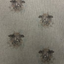 A close-up of a woven fabric with a repeating pattern of sheep faces in muted brown and gray tones on a light beige background.