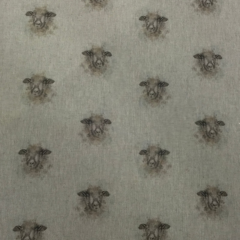 A close-up of fabric featuring a repeating pattern of sheep heads in muted brown and gray tones on a light warm gray background.