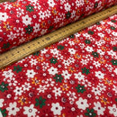 Red floral fabric with white, green, and yellow flowers, shown with a wooden ruler to indicate scale.
