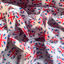 White fabric printed with a repeating Union Jack flag pattern, shown in soft folds.