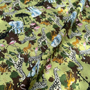 Patterned fabric with various safari animals on a green background