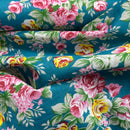 Floral fabric with pink, yellow, and green flowers on a blue background