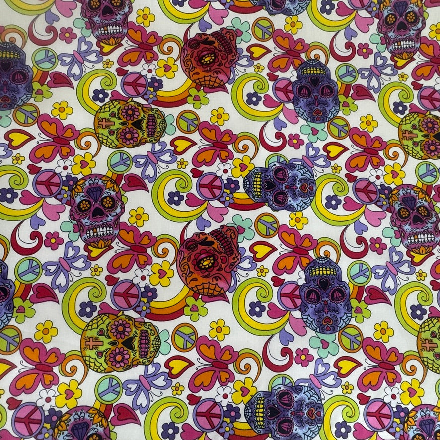 A close-up of a colorful fabric or wallpaper pattern featuring sugar skull illustrations, peace signs, hearts, and floral motifs on a white background.