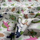 Fabric with colorful dinosaur pattern on a cream background