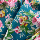 Close-up of floral fabric with pink, yellow, and green flowers on a blue background