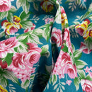 Close-up of floral fabric with pink roses and green leaves on a blue background