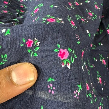 Hand holding navy rosebud viscose fabric to show scale of print - image 6
